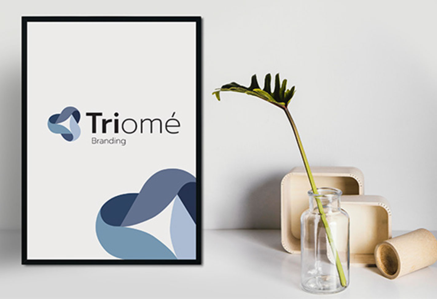 Triomé Branding logo præsenteret i fotoramme på skrivebord - kontakt mig for en uforpligtende snak