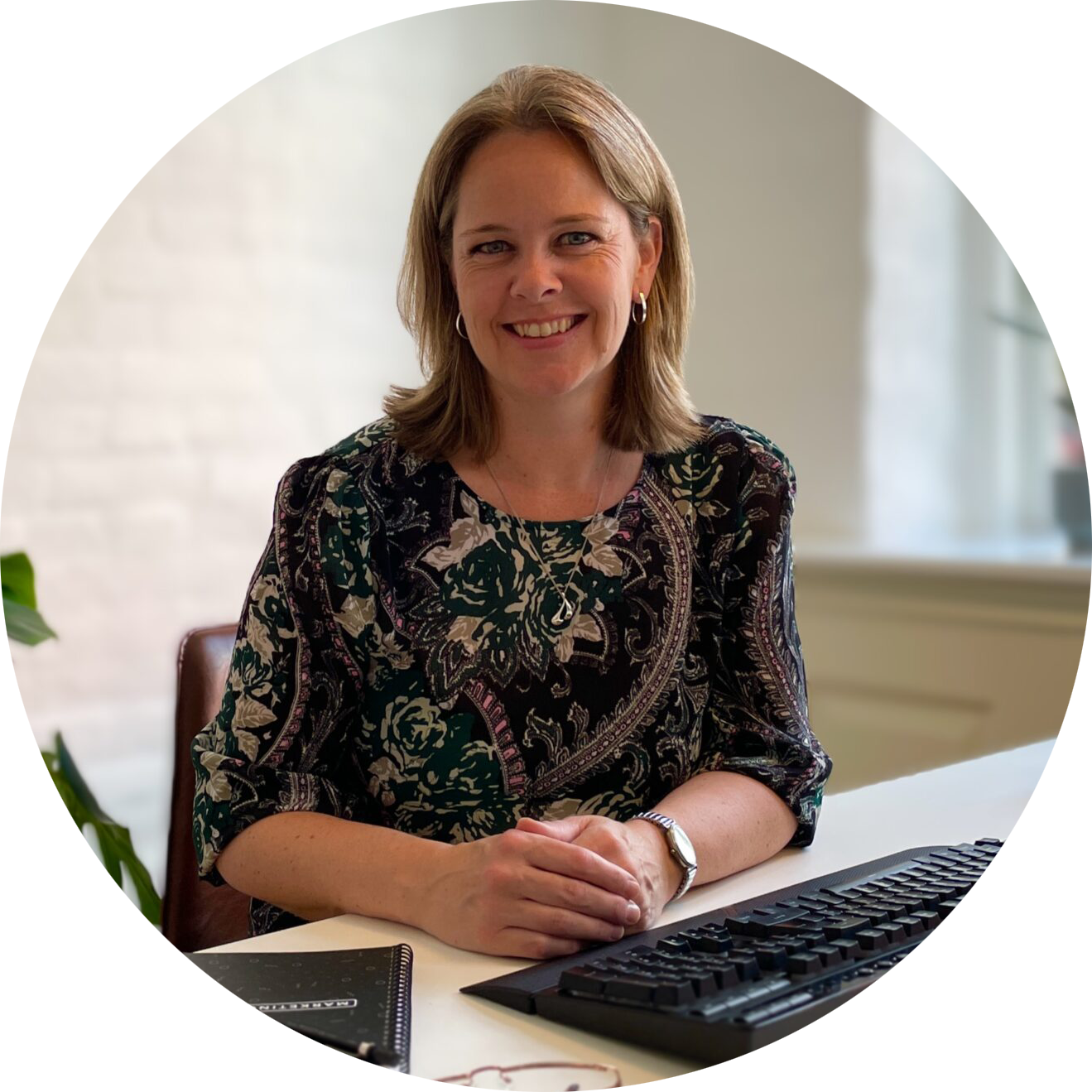 Heidi Philipsen smilende ved skrivebord - branding- og marketingkonsulent i Sønderborg og Sydjylland